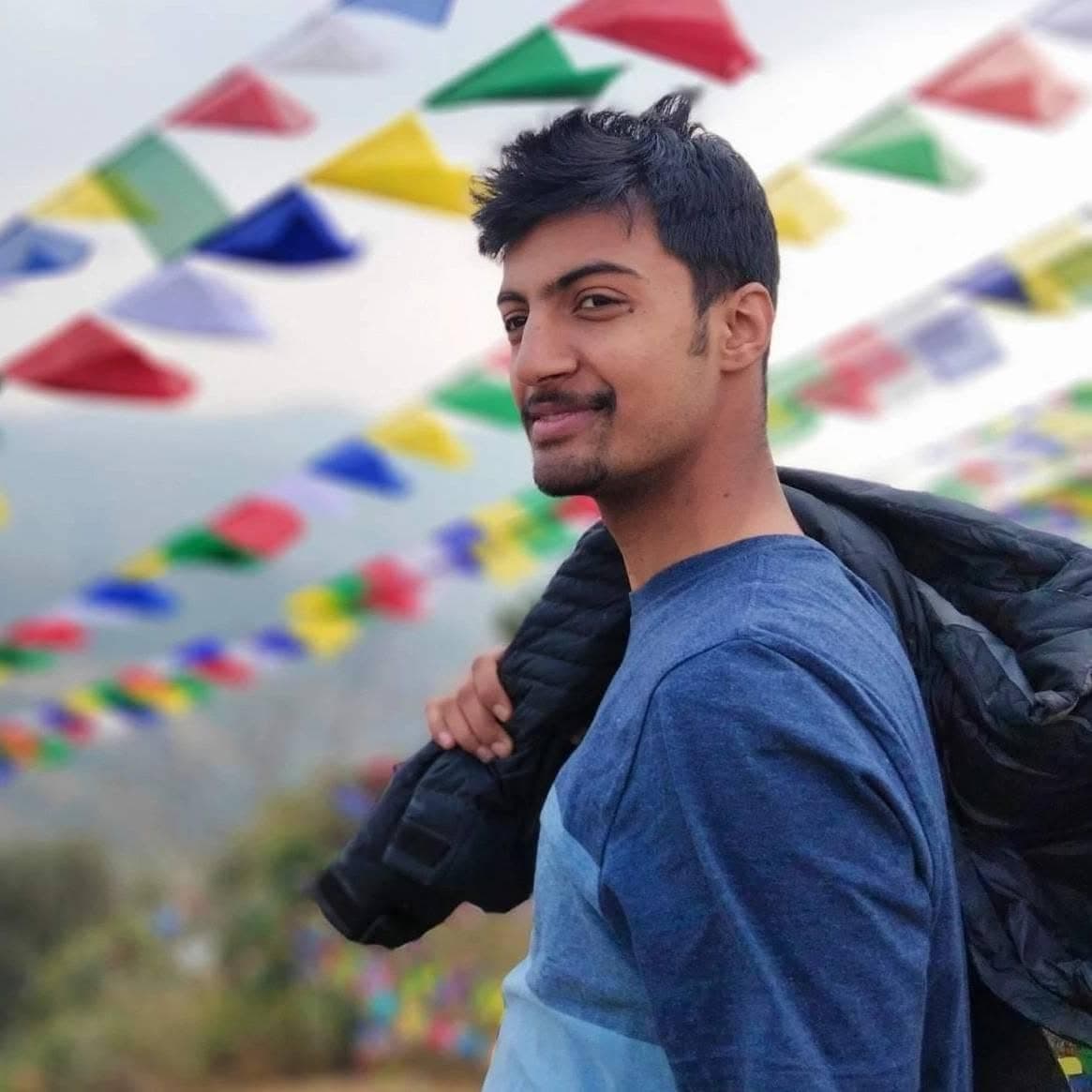 Subarna Poudel, photographed outdoors in Nepal beneath strings of prayer flags.